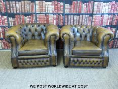 A pair of leather Chesterfield club armchairs with button backs and metal stud decoration,