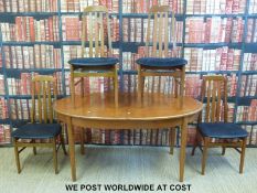 A retro teak table and four chairs with integral extra leaves (H73 x W164 x D90cm)