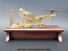 An unusual J & E Ratcliff pick up weight brass postage scale with five captive turned brass weights,