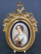 A portrait miniature on porcelain of a seated lady in ornate gilt frame (height 13cm)