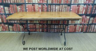 A pine table raised on scrolling metal legs