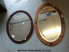 Two oval oak framed mirrors, both with bevelled glass,