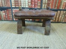 A leather covered upholstered camel saddle with embossed decoration