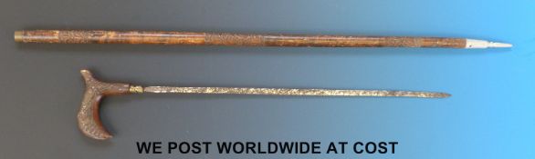 An Eastern sword stick with carved and shaped handle, carved scabbard and metal end.