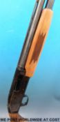 A deactivated Mossburg Slugster pump action shotgun with engraved detail of a stag,