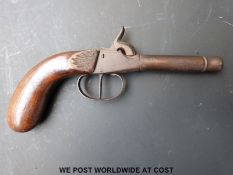 Single barrelled percussion hammer action pocket pistol with carved grip and cannon shaped barrel,