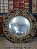 A convex wall mirror in ornate frame (Diameter 46cm)