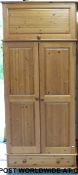 A pine wardrobe with cupboard above and drawer below (W95 D58 H219cm)