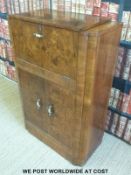 An Art Deco burr walnut drinks or cocktail cabinet with fitted mirrored interior to top section