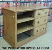 A vintage pine haberdashery shop counter with three straight drawers and three cubbyholes.