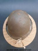 A British Civil defence helmet with canvas carrier and shoulder strap