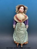 Gebruder Krauss bisque headed doll with fixed blue eyes, open mouth, pierced ears, short brown hair,