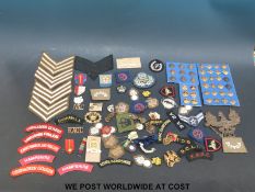 A quantity of British military insignia to include cap badges, cloth,