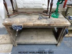 A rustic wood working bench with vice and clamp