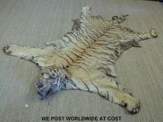A late 19th or early 20th taxidermy tiger skin rug with head and claws (length 240cm) with Guild of