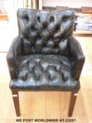 A black leather chair with button back and seat