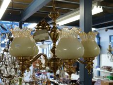 A contemporary five branch brass lamp fitting with glass shades with a pair of matching wall lights,