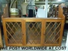 A three-door glazed wall cabinet (W122 D26cm H91cm)