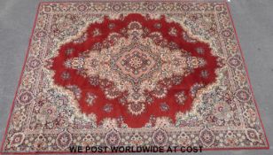 A large Wilton style carpet with red ground (396 x 296cm)