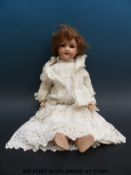 An Armand Marseille bisque headed doll with weighted blue eyes, open mouth,
