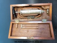 A cased large metal syringe and attachments, possibly for lumbar puncture,