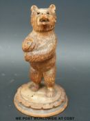 A carved Black Forest bear with glass bead eyes (19cm tall)