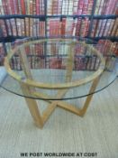 A contemporary oak and glass topped table (diameter 120cm,