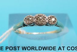 A yellow metal ring set with three diamonds in a platinum setting (size L)