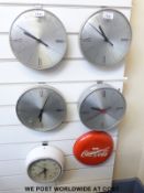 Four 'slave' dial clocks together with an Astral electric clock and a Coca Cola advertising clock