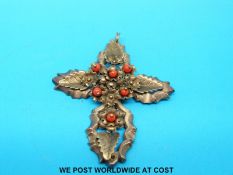 A yellow metal pendant in the form of a cross set with beads