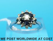 An 18ct white gold ring set with a diamond to the centre surrounded by sapphires and a further