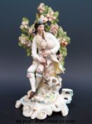An 18thC Derby patch figure of a piper and his dog on a rococo base,