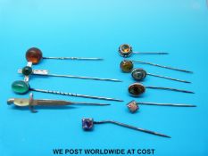 Eight white metal stick pins, set with amber, citrine,