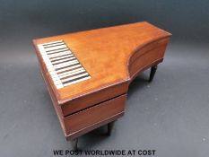 A novelty musical jewellery / sewing box in the form of a piano mounted on turned wooden legs,