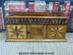 An early 20thC apprentice small free standing parquetry cabinet with gallery above.