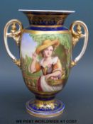 A 19thC twin handled porcelain pedestal urn decorated with a lady carrying a basket of fruit in a