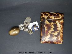 A tortoiseshell card case and a white metal charm,