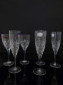 Four Royal Doulton glass champagne flutes in original boxes and a pair of similar wine glasses in