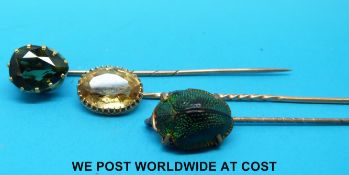 A yellow metal stick pin set with a scarab beetle,