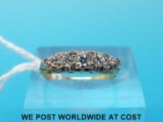 A yellow metal ring marked 18ct set with five round cut diamonds with smaller old cut diamonds