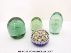 Four glass paperweights, one with various multicoloured and latticino canes on blue ground,