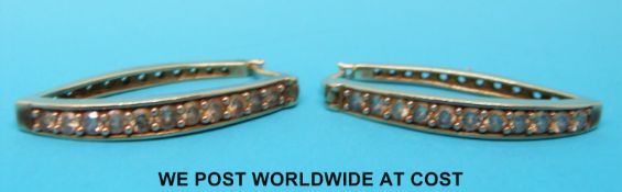 A pair of 9ct gold earrings set with champagne coloured diamonds in a row