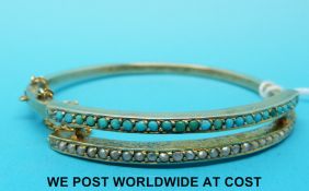 A yellow metal bangle set with a row of seed pearls and a row of turquoise (11.