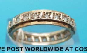 A yellow metal eternity ring set with glass (size P)