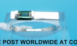 A white metal ring marked 14k set with green tourmaline (size N)
