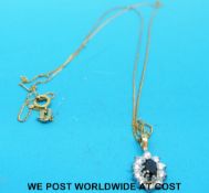A 9ct gold pendant set with a sapphire surrounded by diamonds on a 9ct gold chain
