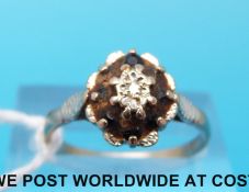 An 18ct white gold ring set with a diamond surrounded by sapphires (size N)