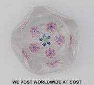 A faceted patterned millefiori glass paperweight with central signature 'D' cane surrounded by five
