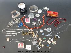 Two silver charm bracelets, a silver brooch, silver mounted cheeroot holder,