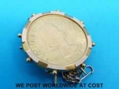 A yellow metal brooch set with 1957 gold full sovereign (10.